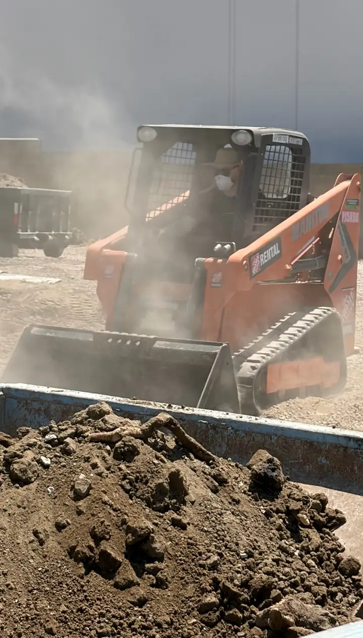 Arman running a skid steer on a job
